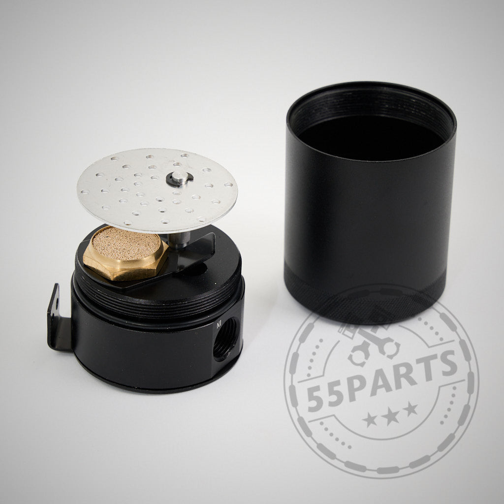 Das 55Parts Exclusive Externes PCV-System „Leerlaufseite“ passend für BMW N54 (135i, 1er M Coupé, 335i(x)) verfügt über ein schwarzes zylindrisches Teil mit einer perforierten Metallscheibe und einem Messingbeschlag, hier neben dem Deckel abgebildet.