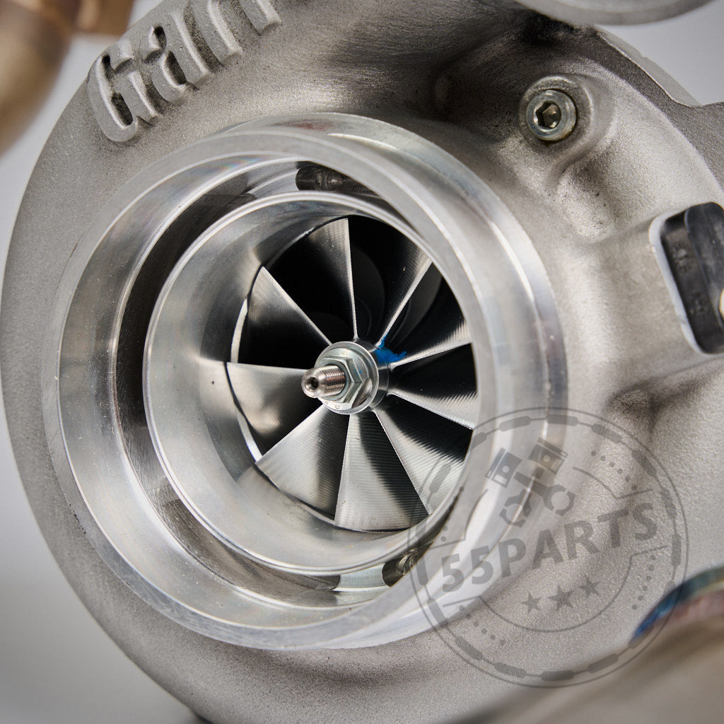Nahaufnahme einer Turboladerturbine mit sichtbaren Schaufeln, die das 55Parts-Special zeigt: Big Turbo Kit 1000 PS für B58 Gen.1 (kompatibel mit F2X, F3X, G3X, G01 X3, G02 X4), mit dem 55Parts-Logo-Wasserzeichen im Vordergrund.