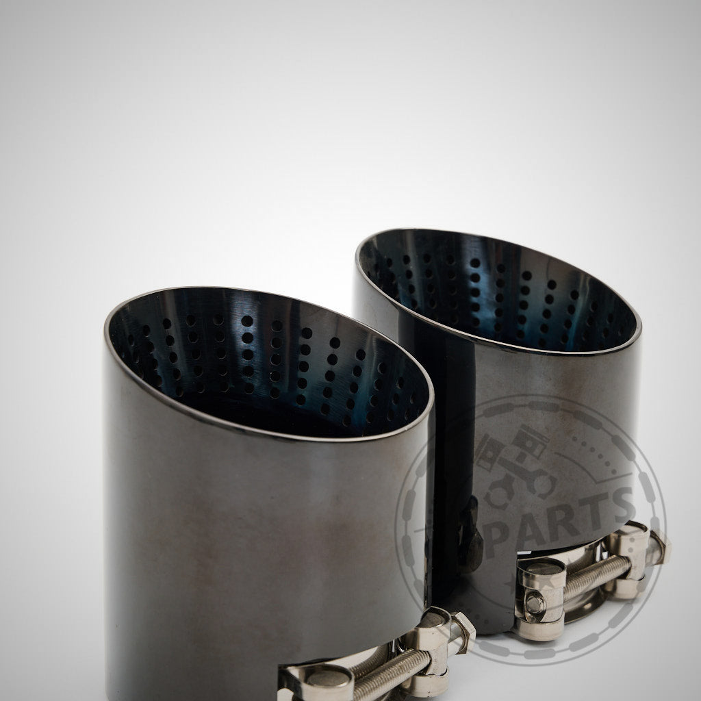 Schwarze, abgeschrägte Doppelauspuffblenden mit perforierter Innenseite und Metallklammern, entworfen für die 55Parts Special 3&quot; ECE Equal Length-Auspuffanlage für alle BMW F8x M2 Competition-, M3- und M4-Modelle.