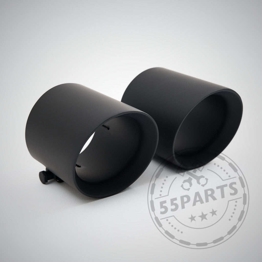 Ein Paar schwarze Metall-Auspuffblenden für die 55Parts-Sonderanfertigung: 3" ECE-Abgasanlage, passend für BMW G8x-Modelle (G81, G82, G83, G87 M2/M3/M4 Competition/Touring) mit S58-Motor, abgebildet auf einer hellen Oberfläche mit dem 55Parts-Logo-Wasserzeichen.