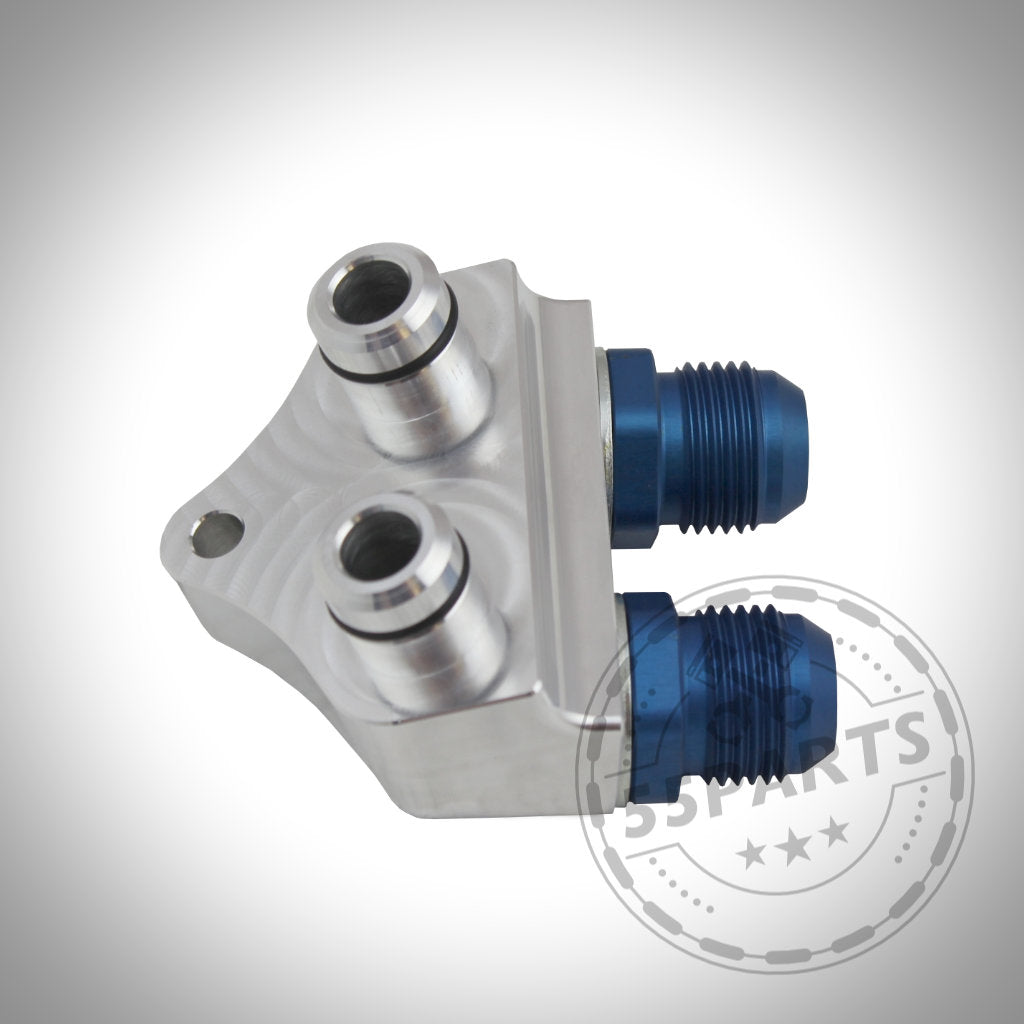 Exklusiv bei 55Parts: Ölkühleradapter für ZF 8HP50 und 8HP70 Dash10 – ein Aluminium-Autoteil passend für BMW-Motoren mit zwei silbernen Anschlüssen und zwei blauen Gewindeanschlüssen, konzipiert für Kühlsystemanwendungen, dargestellt auf weißem Hintergrund.