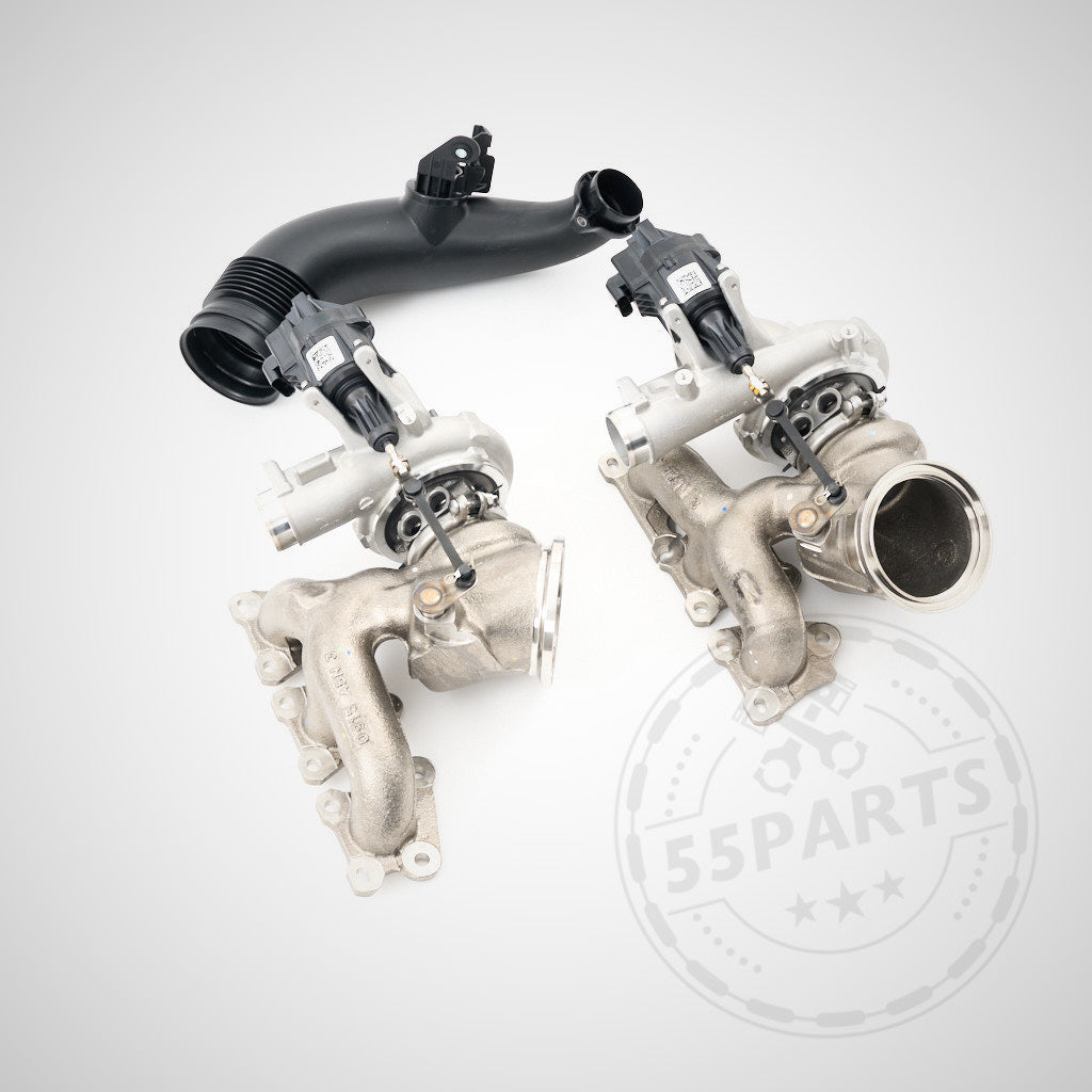 Auf hellem Untergrund mit 55Parts-Wasserzeichen sind zwei Ladermanufaktur Upgrade Turbolader LM700-LM900 passend für BMW F80/F82/F87 M2C/M3/M4 S55 Motor und ein schwarzes Ansaugrohr abgebildet.