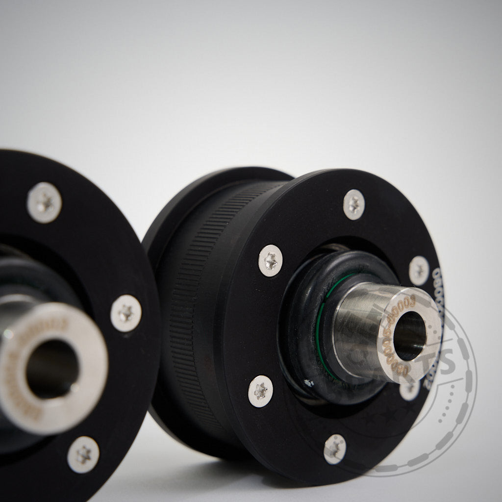 Nahaufnahme von zwei schwarzen NoFlex-Lagern: Uniball Lager vordere Zugstrebe, mit Bolzen und zylindrischem Zentrum, passend für BMW 2er, 3er, 4er, Z4 G-Serie inkl. xDrive und alle Toyota Supra GR-Motoren, auf hellem Hintergrund.