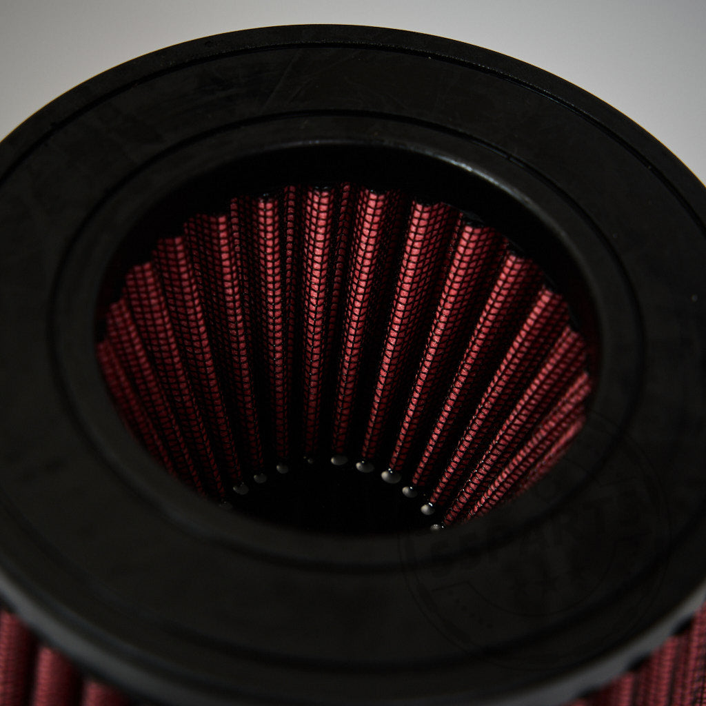 Nahaufnahme eines roten zylindrischen Luftfilters mit schwarzer Gummikante, entwickelt für das Ansaugsystem Dual Cone Intake passend für BMW G87 M2, G80/G81 M3, G82/G83 M4 S58 – perfekt für Ihre Ansaug- oder FBO-Konfiguration.