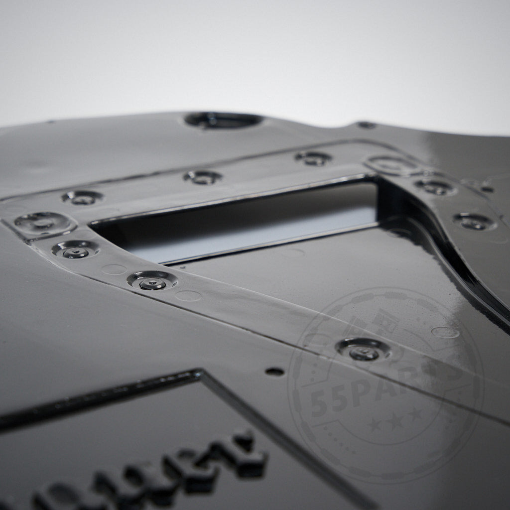 Nahaufnahme eines schwarzen Metall-GFK-Unterbodens inkl. Differential- und Getriebekühlung &amp; Polybauer Automotive, entworfen für Toyota GR Yaris, mit Schrauben und einem offenen rechteckigen Ausschnitt.