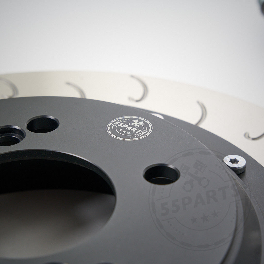 Nahaufnahme des 55Parts-Specials: AP Racing CP9449 Big Brake Kit Hinterachse (355x32/378x32), ein schwarzes Metallteil mit Logo und Schrauben, entworfen für viele BMW Modelle – ideal für Serienbremsen und Rennstrecke.