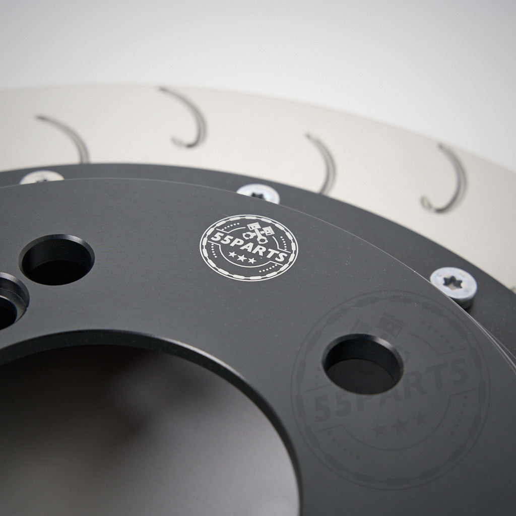 Nahaufnahme einer 55Parts Special AP Racing CP9449 Big Brake Kit-Hinterradbremsscheibe (355 x 32/378 x 32, Aftermarket) für viele BMW-Modelle, mit dem 55Parts-Logo und detaillierten Schrauben, inspiriert von Rennstrecke-Serienbremsen.