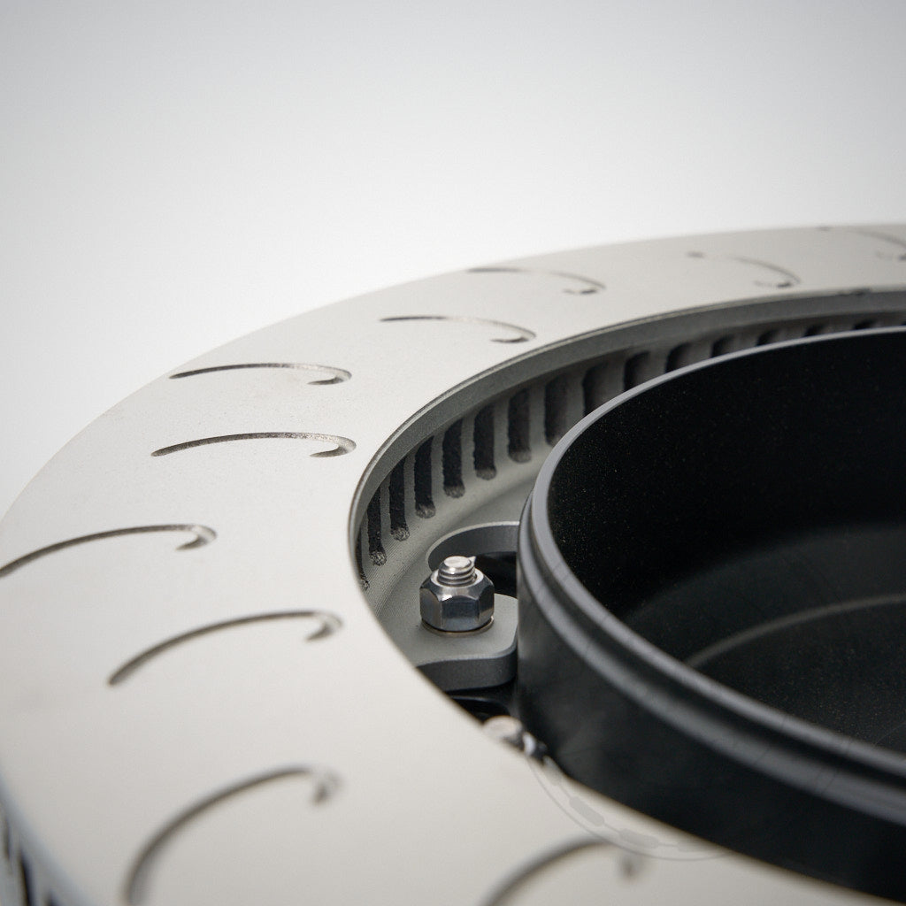 Nahaufnahme eines 55Parts AP Racing CP9449 Big Brake Kit (hinten, 355x32 oder 378x32 Aftermarket-Scheiben) mit gebogenen Schlitzen und schwarzer Nabe, entworfen für viele BMW-Modelle und inspiriert von der Rennstreckenleistung.