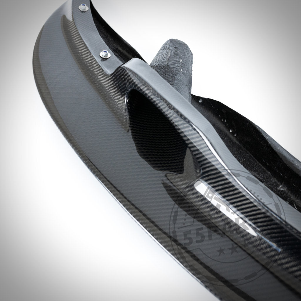 Nahaufnahme der 55Parts Echtcarbon Frontschwert-Frontlippe GT4 mit Bremsbelüftung, entworfen für den BMW E9x M3, die ihren belüfteten Kohlefaserstil vor einem weißen Hintergrund zeigt.