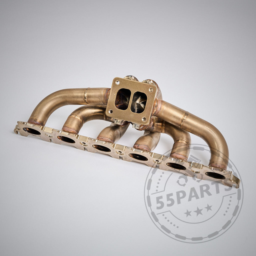 Das 55Parts Special: Big Turbo Kit 1000PS für B58 Gen. 1 (F2X, F3X, G3X, G1X, G01, G02) verfügt über einen Edelstahl-Auspuffkrümmer mit sechs Rohren und einem quadratischen Flansch, abgebildet auf einem hellen Hintergrund.