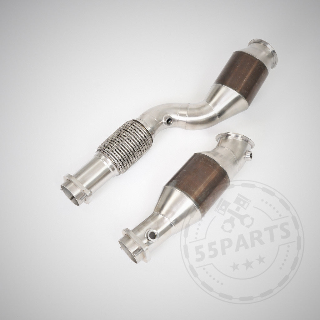 Zwei High Flow Downpipes (mit 200 Zeller Euro 6 Katalysatoren) & MH Pipes passend für BMW G80 M3/G82 M4 S58, mit flexibler Verbindung und integriertem Downpipe, abgebildet auf hellem Hintergrund.