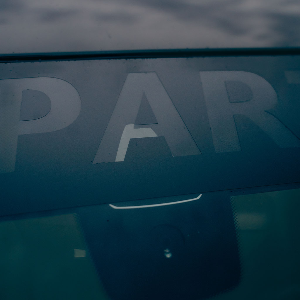 Nahaufnahme einer Autowindschutzscheibe, auf der „PART“ durch das getönte Glas sichtbar ist, mit 55Parts Scheibenkeil passend für alle Autos von 55Parts für blasenfreies Anbringen.