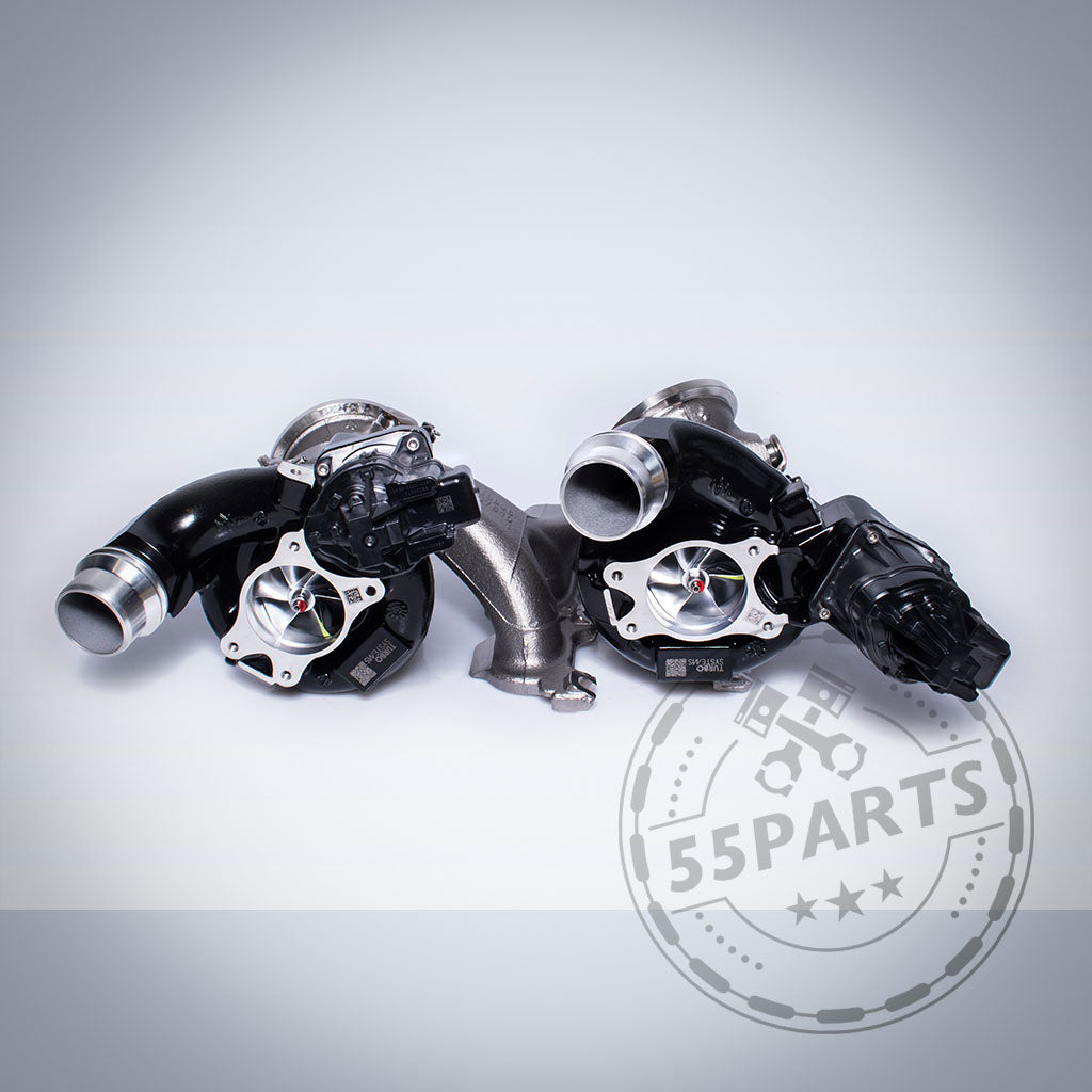 Zwei schwarze Turbosystems Upgrade-Turbolader-Einheiten für die Motoren BMW G87 M2, G80/G81 M3, G82/G83 M4, F97 X3M und F98 X4M S58 auf hellem Hintergrund mit einem 55Parts-Logo-Wasserzeichen in der Ecke.