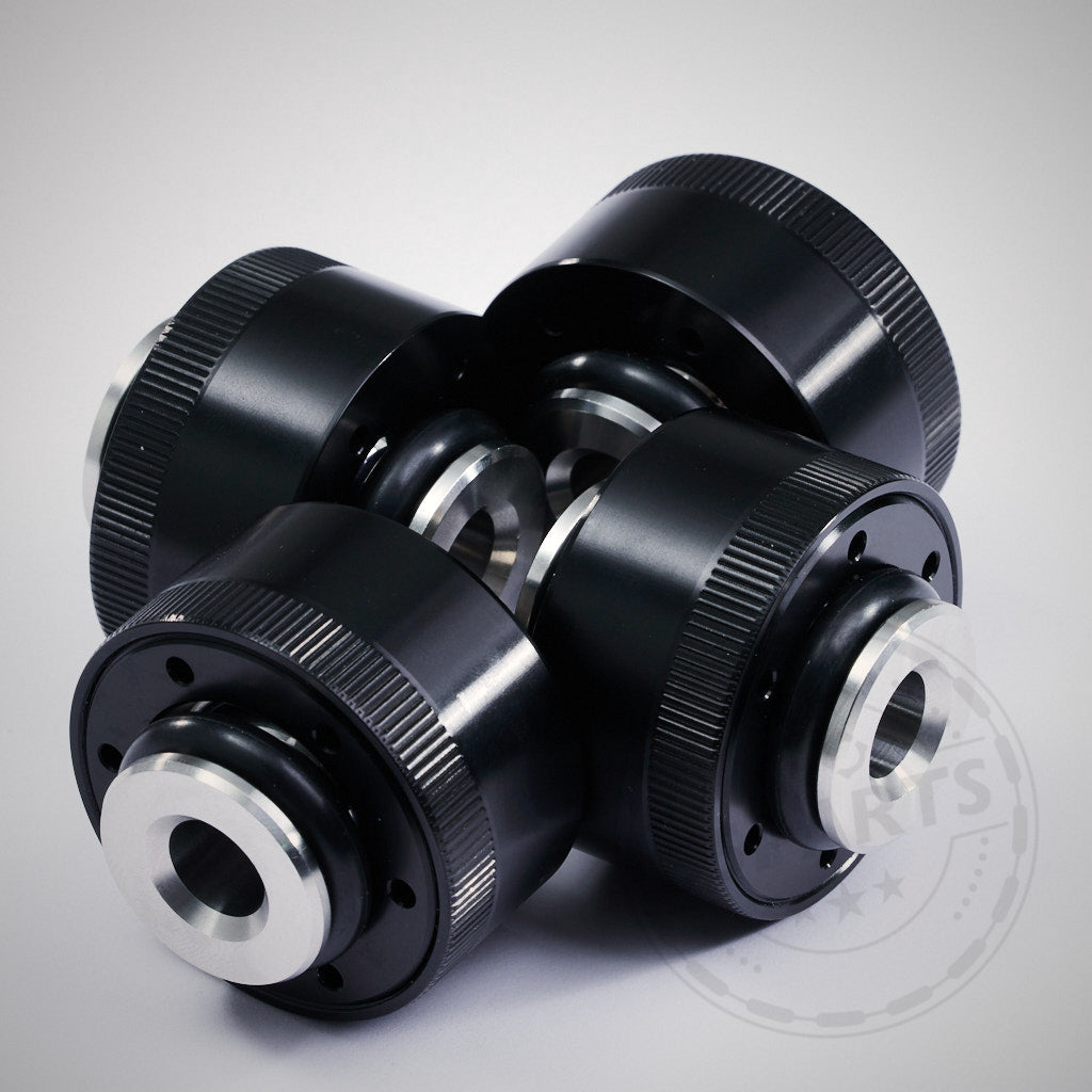 Vier schwarze und silberne NoFlex-Lager – Upgrade Uniball Lager für originalen unteren Querlenker, Spurlenker passend für BMW F8x und G8x M-Modelle – sind kreuzförmig auf hellem Hintergrund angeordnet.