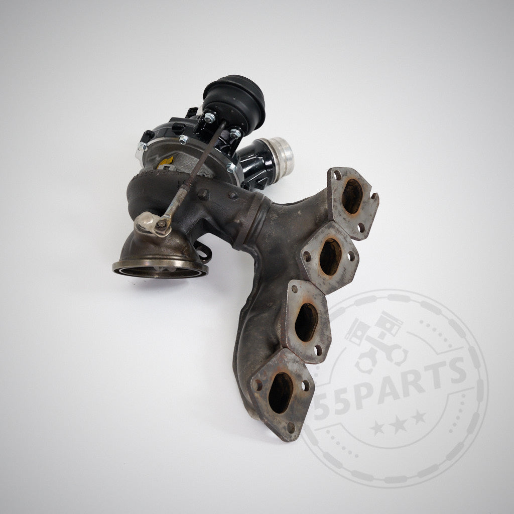 Turbolader mit Abgaskrümmer auf weißem Hintergrund, ausgestattet mit dem Turbosystems Upgrade Turbolader passend für BMW F2x, F3x 114i, 116i, 118i, 120i, 316i, 318i, 320i mit N13-Motor.