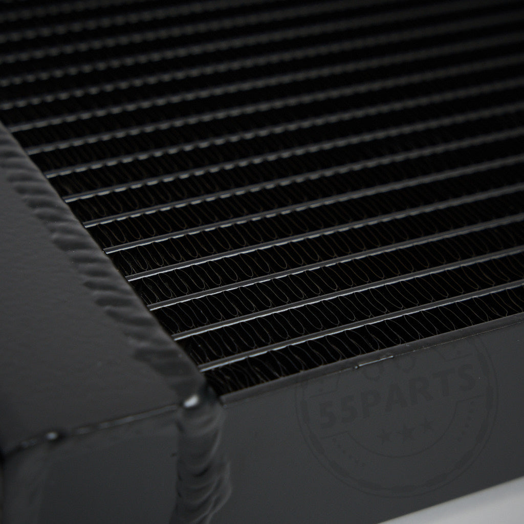 Nahaufnahme eines 55Parts Aluminium-Upgrade-Kühlmittelkühlers, seitlicher Wasserkühler passend für BMW M2 Competition, M3, M4 F8x S55, mit parallelen Lamellen und sichtbaren Schweißnähten für effiziente Kühlung.