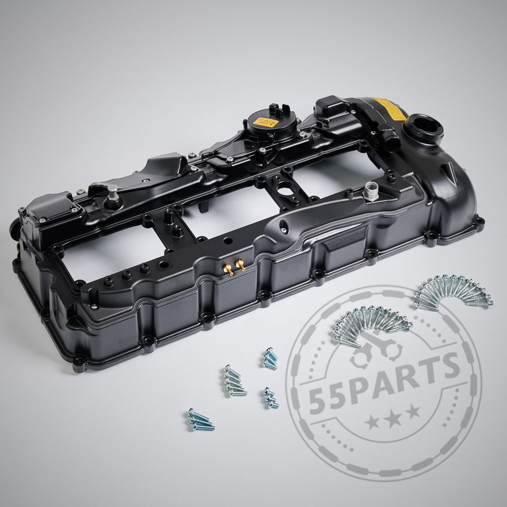 Der schwarze Aluminium-Ventildeckel EXCLUSIVE, abgebildet mit Schrauben und Bolzen auf hellgrauem Hintergrund, passt für die BMW N55-Motormodelle (M)135i, M235i, 335i, 435i, 535i und 640i.