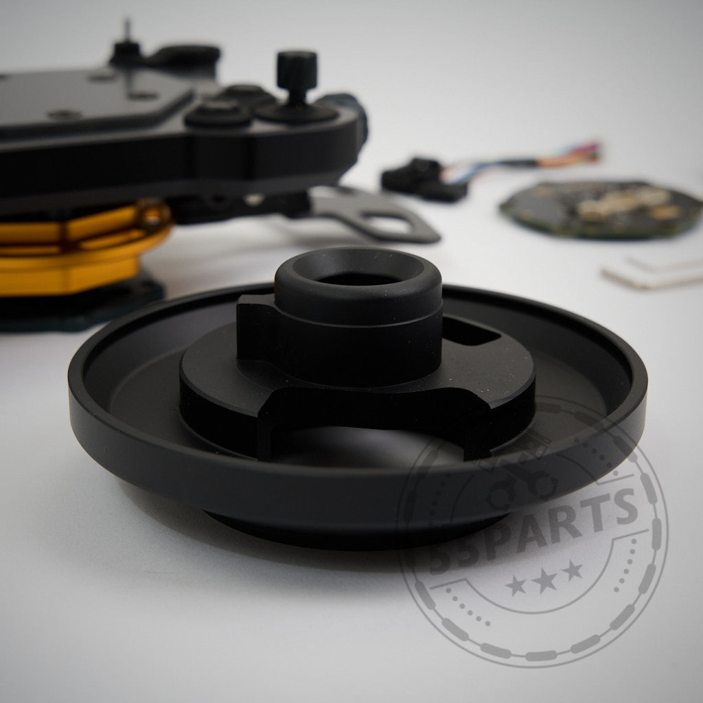 Schwarzer, runder 55Parts Zestek Lenkrad HUB mit Rillen, passend für alle BMW E-, F- und G-Serie sowie Toyota Yaris/Supra – mechanisches Bauteil auf weißer Fläche neben weiteren Komponenten, ermöglicht schnellen Quick Release Mechanismus.