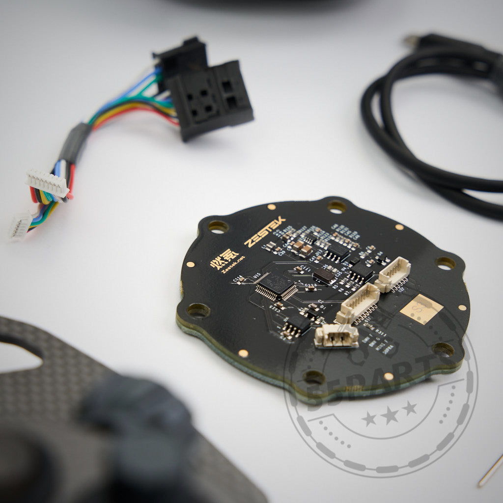 Auf einer weißen Oberfläche befindet sich eine runde schwarze Platine mit Anschlüssen und Kabeln, konzipiert für die Verwendung mit dem 55Parts Exklusiv: Zestek Lenkrad HUB für alle BMW E-, F-, G-Serien und Toyota Yaris/Supra.