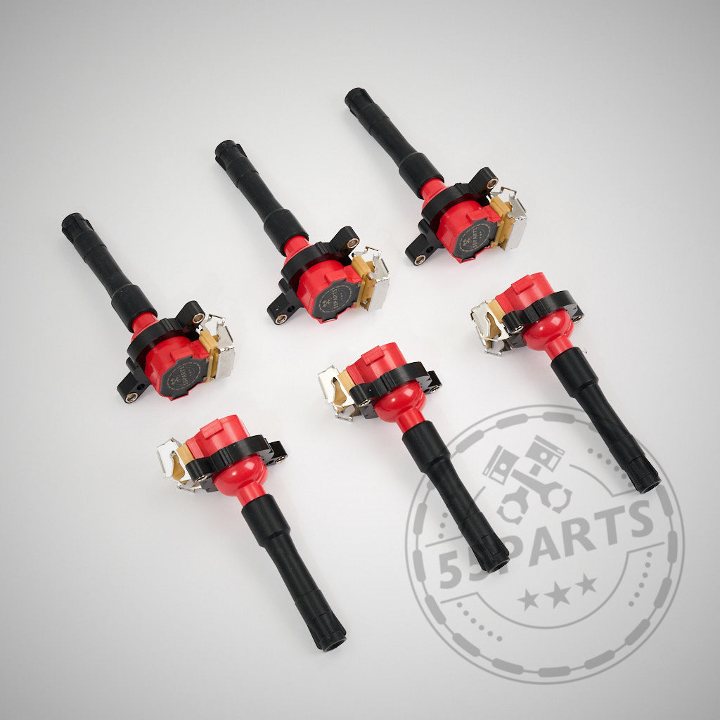 Sechs 55Parts Special Zündspulen passend für BMW M52, M54, M62, M73, S52 und S62 Motoren liegen auf grauem Grund mit dezentem Auto-Logo – perfekt für präzise Zündwinkel-Steuerung.