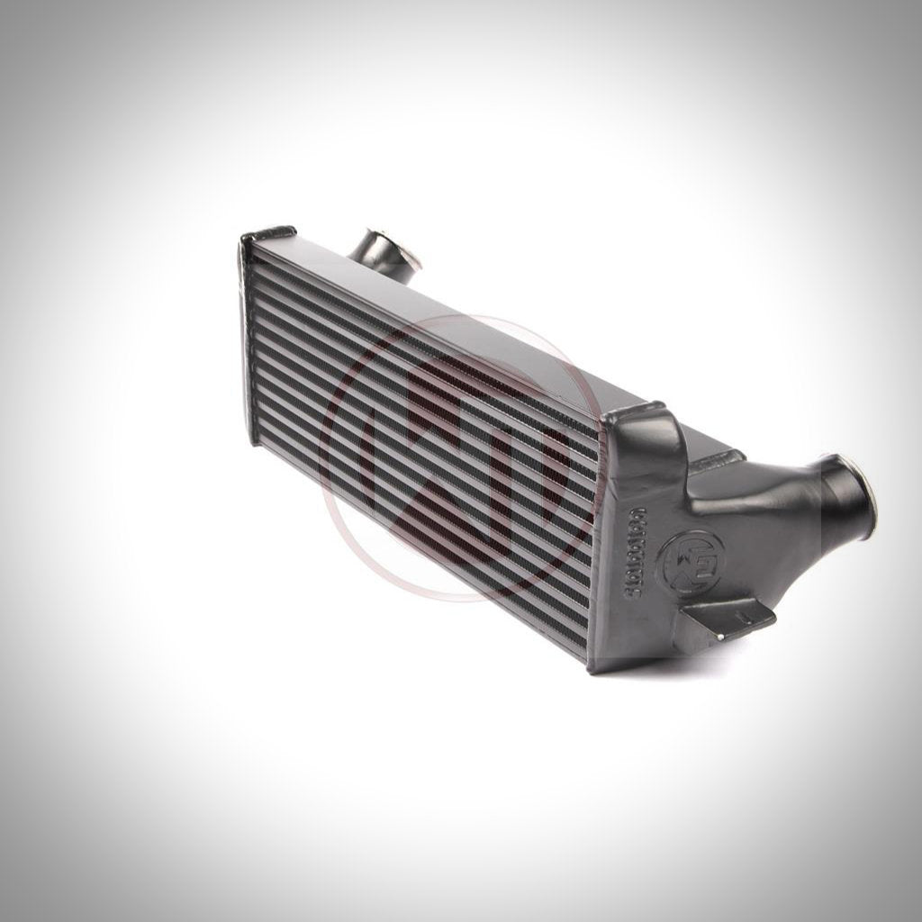 Das Wagner Tuning Evo 2 Competition Ladeluftkühler-Kit passend für BMW 135i, 1er M Coupé und 335i(x) N54/N55 E-Serie umfasst Klemmen, Kupplungen und einen schwarzen Silikonschlauch, abgebildet auf weißem Hintergrund.