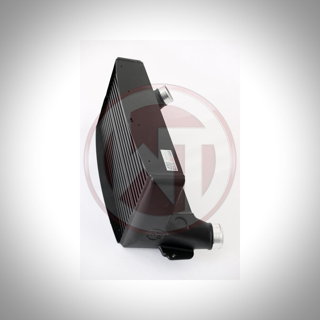 Der Wagner Tuning Evo 3 Ladeluftkühler passend für BMW 135i, 1er M Coupé und 335i(x) N54/N55 E-Serie ist ein schwarzer Ladeluftkühler mit abgewinkelten Anschlüssen, dargestellt auf weißem Hintergrund.