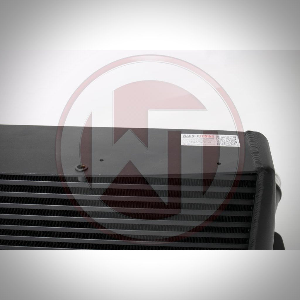 Nahaufnahme eines Wagner Tuning Evo 3 Ladeluftkühlers, schwarz mit weißem Etikett in der oberen Ecke, entwickelt passend für BMW 135i, 1er M Coupé und 335i(x) N54/N55 E-Serie, vor weißem Hintergrund.