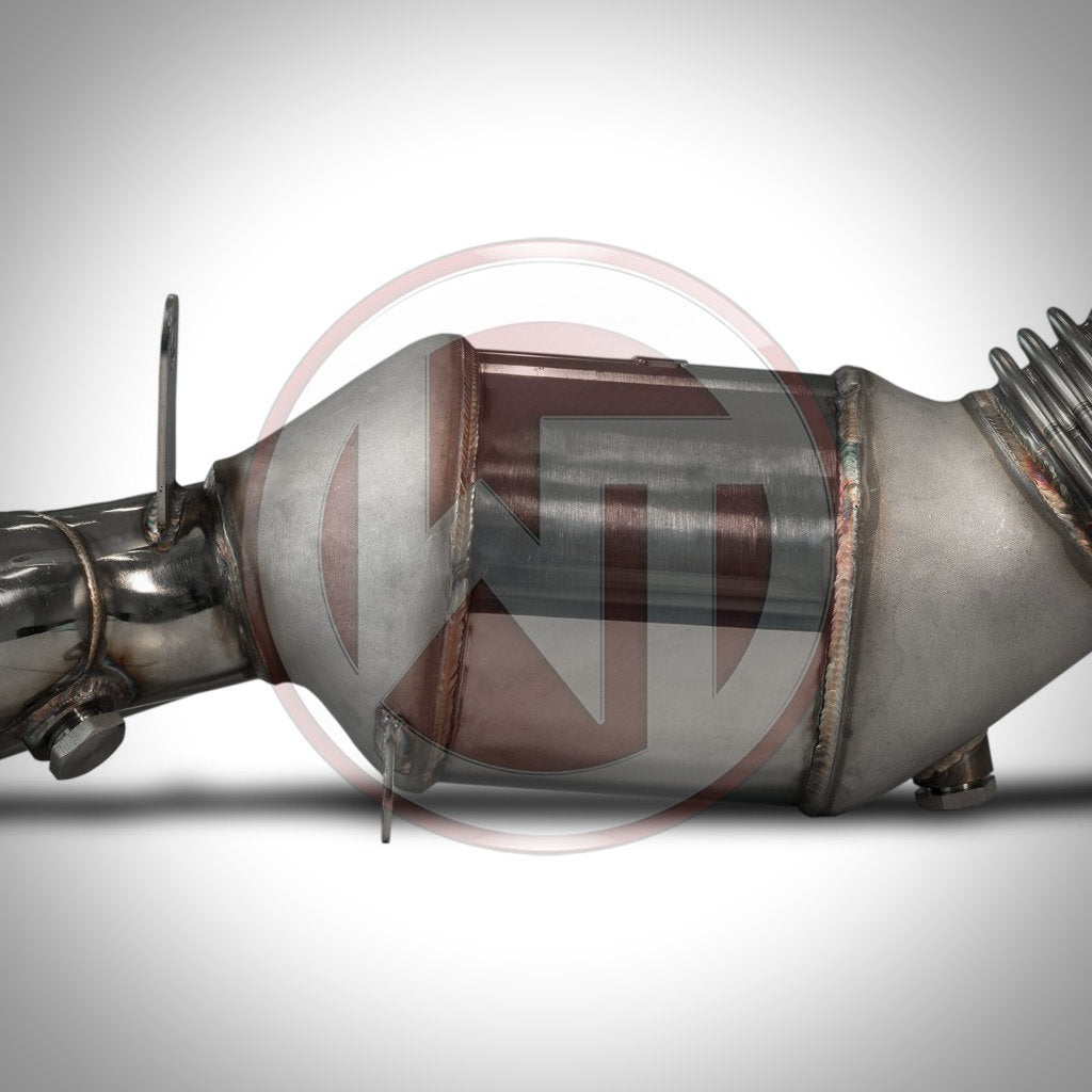 Eine Nahaufnahme der Wagner Tuning High Flow Downpipe mit 200-Zeller-Katalysator für die BMW 135i/335i(x) N55 E-Serie zeigt ihren Querschnitt und ihr optimiertes Strömungsdesign, ideal für FBO-Setups.