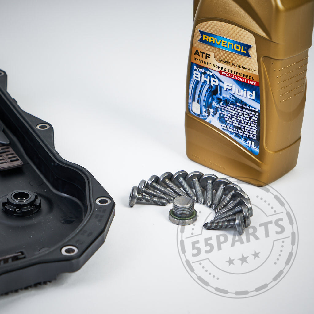 Auf einer weißen Fläche wird ein 55Partss Getriebeölwechsel-Set präsentiert, das aus einer Flasche Getriebeöl, einem schwarzen Autoteil und mehreren Schrauben besteht.