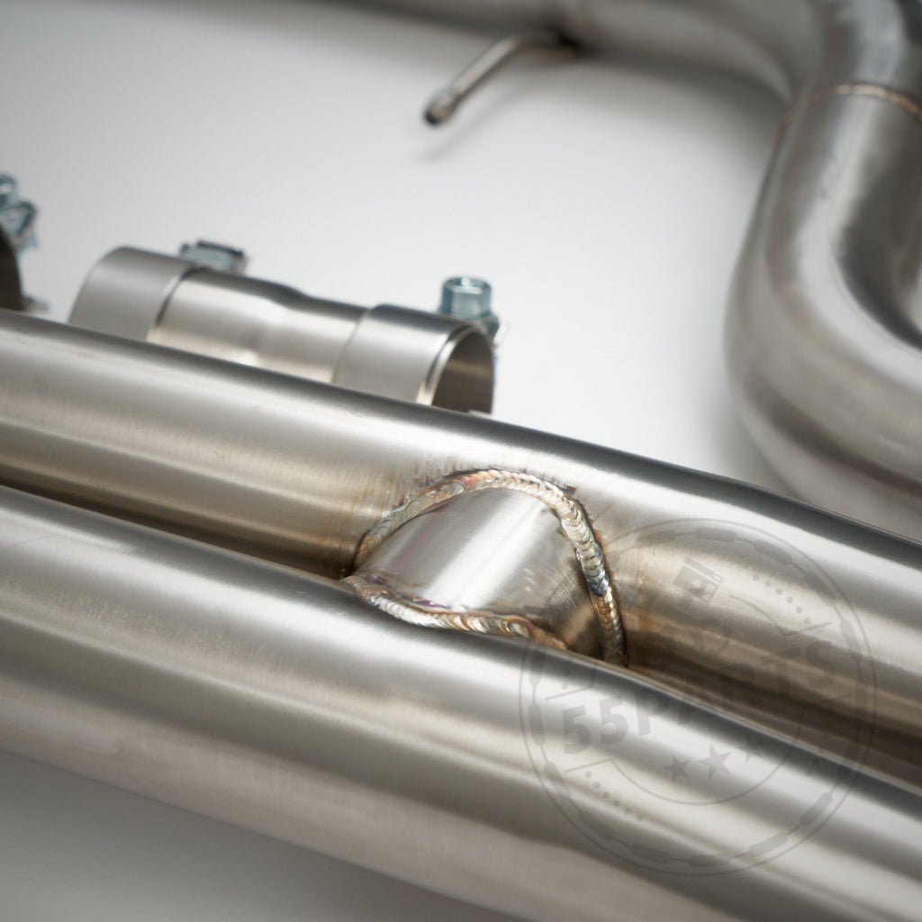 Nahaufnahme der 55Parts High Flow Midpipe ohne OPF und Kats, passend für BMW M2 Competition, mit geschweißten Edelstahlrohren mit einer Klemme für optimale Leistung, vor einem schlichten weißen Hintergrund.