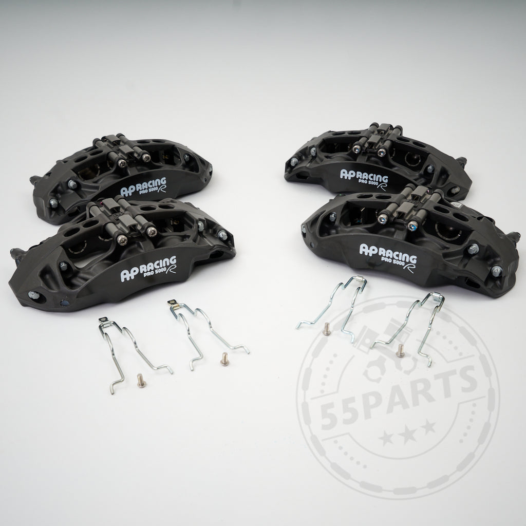 Auf einer weißen Fläche sind vier schwarze 55Parts AP Racing Pro 5000 R CP9665 Big Brake Kit Bremssättel mit Metallclips passend für BMW Modelle abgebildet – ein ideales Upgrade gegenüber Serienbremsen für eine verbesserte Rennstrecken-Performance.