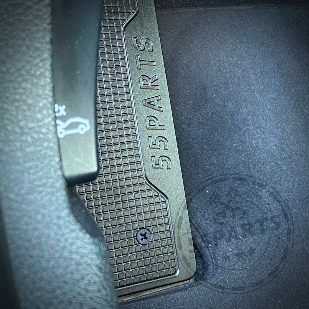 Nahaufnahme eines Autoinnenraums mit der 55Parts Special Aluminium Fußstütze Fußablage mit 55Parts Logo, passend für BMW F2x, F3x und F8x Modelle, neben dem Kofferraumentriegelungshebel.
