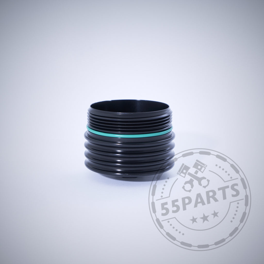 Die 55Parts Exclusive Aluminium Ölfilterkappe mit Sechskant in Schwarz mit grünem Dichtring, passend für BMW N20, N57, N52, N53, N54, N55, S55, B46, B48, B57 und B58 Motoren auf hellgrauem Hintergrund.