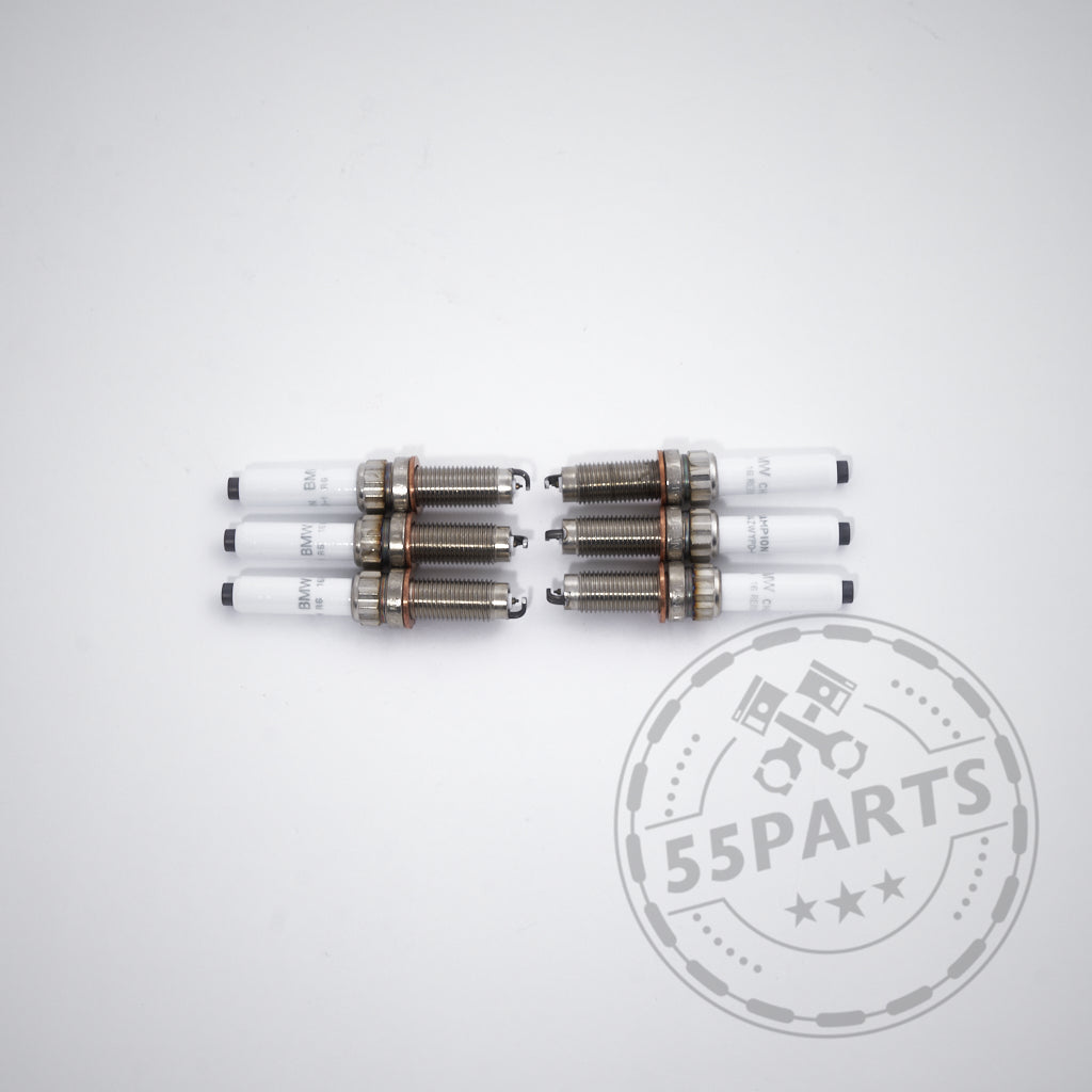 Ein Satz von vier BMW Zündkerzen für 6-Zylinder-Motoren, angeordnet in zwei Paaren auf weißem Hintergrund mit dem 55Parts-Logo. Passend für M240i, M340i, M440i, G8x M2/M3/M4, X3M und A90 Supra B58.