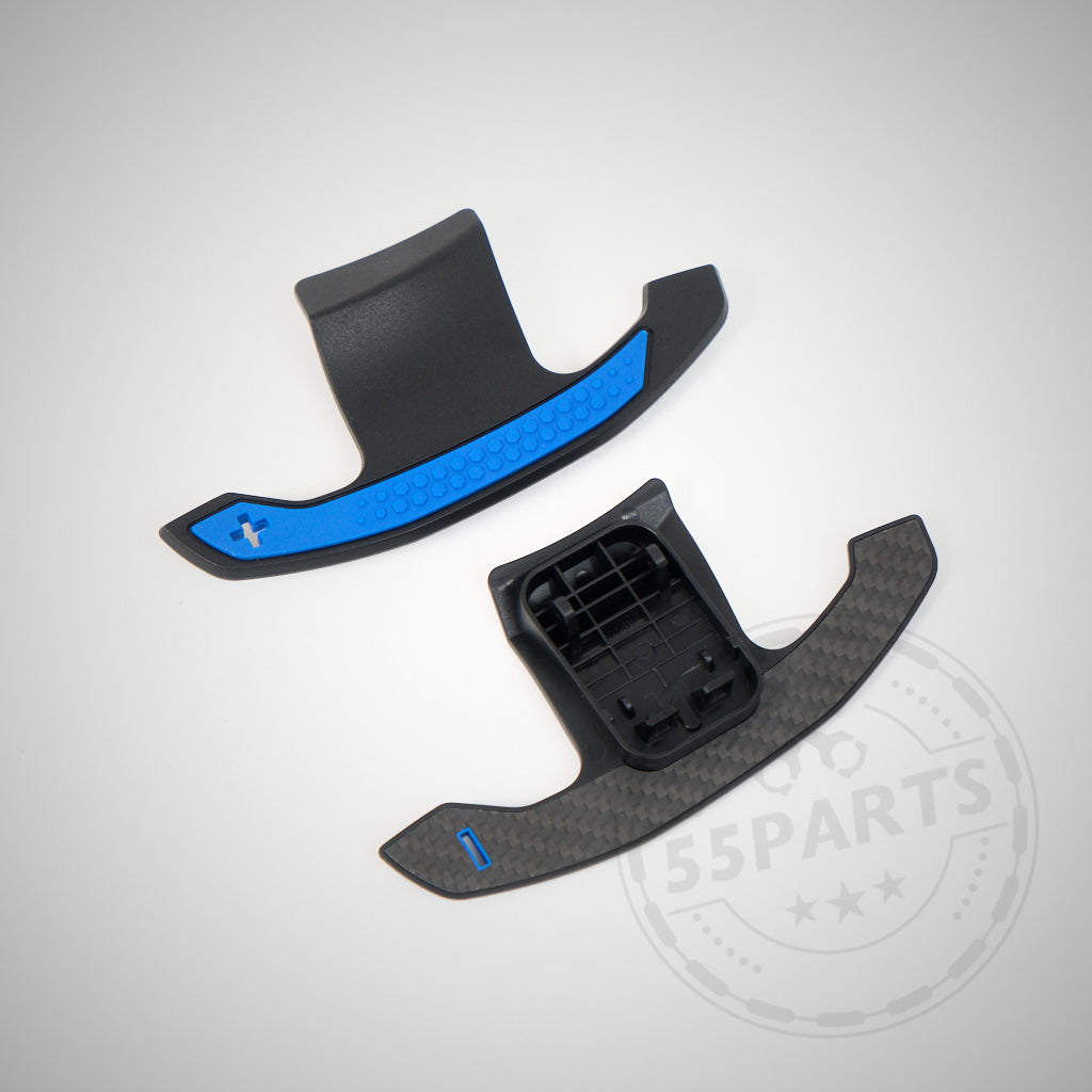 Zwei Carbon-Schaltwippen, eine mit blauem Akzent, auf hellem Hintergrund dargestellt. Passend passend für BMW 1/2/3/4 35 & 40i, M2, M3 und M4 F- und G-Serie.