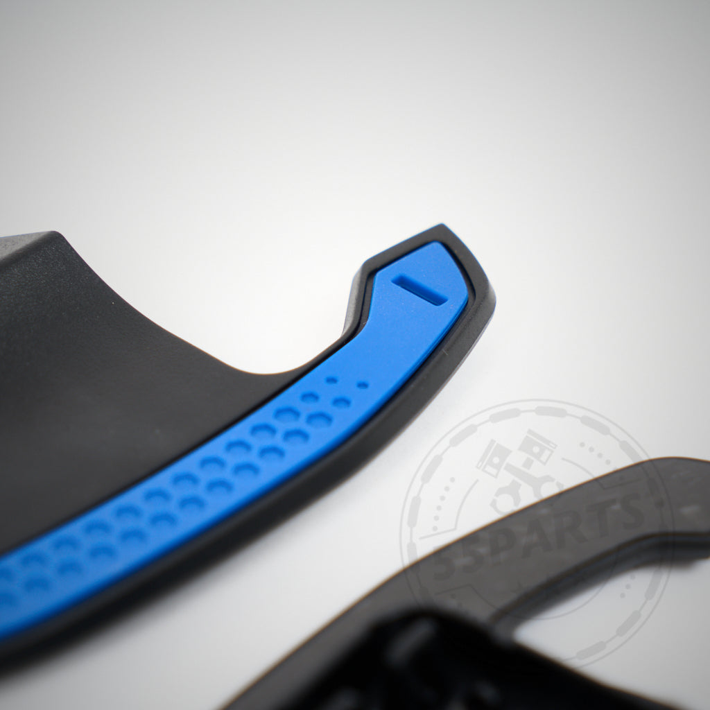 Nahaufnahme der 55Parts Carbon-Schaltwippen mit strukturiertem Griff und eckigem Design passend für BMW 1/2/3/4 35 & 40i, M2, M3 und M4 F- und G-Serie auf weißem Hintergrund.