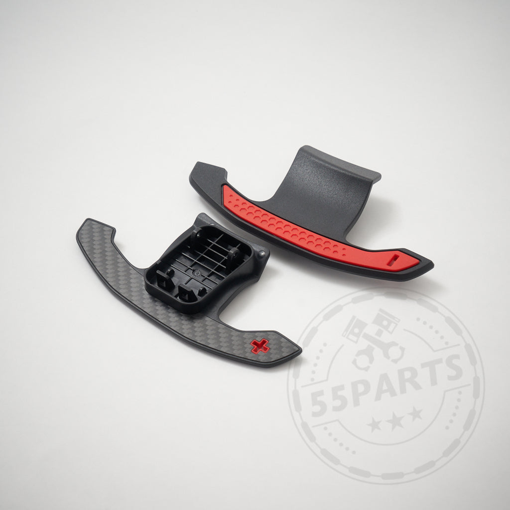 Ein Paar Carbon-Schaltwippen für die Modelle der F- und G-Serie BMW 1/235/40i, 3/435/40i, M2, M3 und M4, mit einem dezenten Logo-Wasserzeichen in der Ecke.