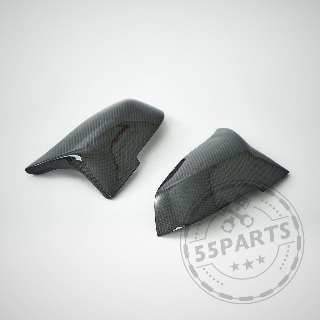 Zwei schwarze 55Parts Spiegelkappen Design-Spiegelabdeckungen passend für BMW F87 F2x F3x M2 M135i M140i M340i werden auf einem hellgrauen Hintergrund mit dem 55Parts-Wasserzeichen angezeigt.