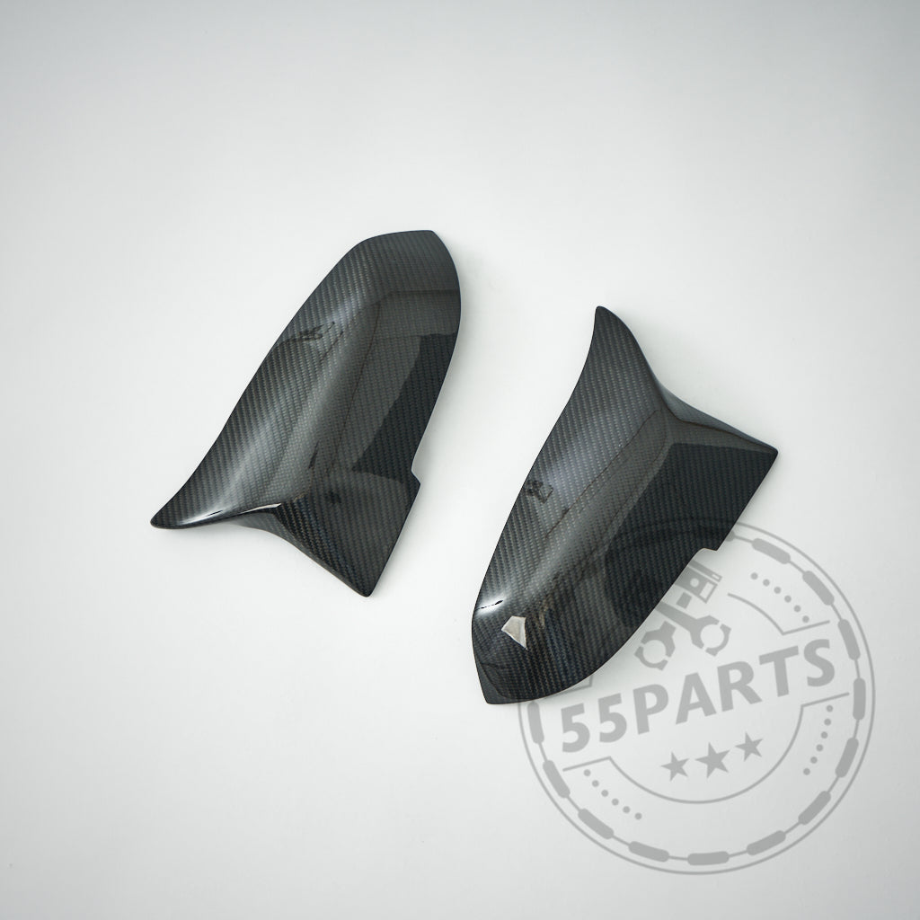 Zwei Spiegelkappen 55Parts Design passend für BMW F87 F2x F3x M2 M135i M140i M340i werden auf einem weißen Hintergrund mit einem 55Parts-Wasserzeichen in der Ecke angezeigt.