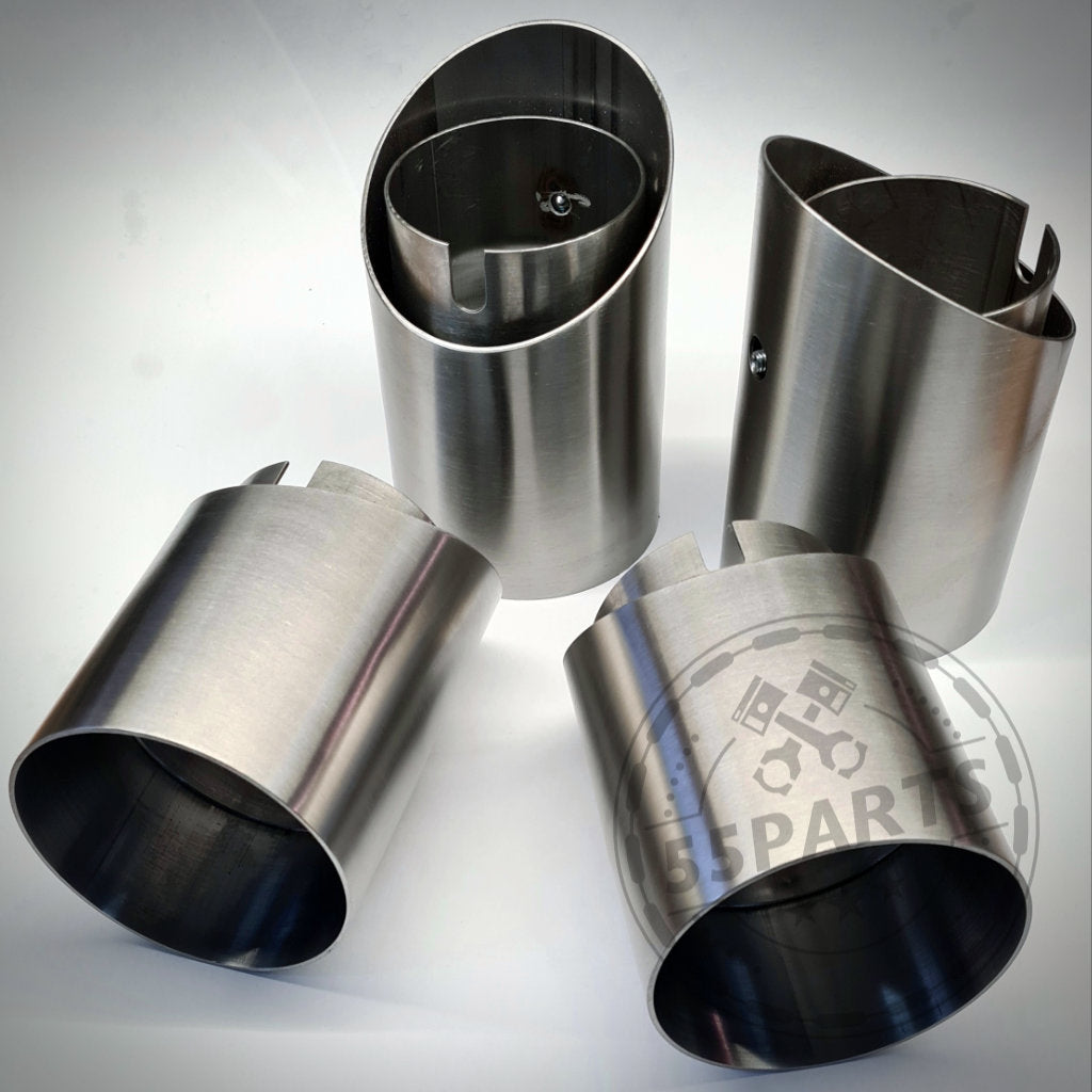 Vier 55Parts Special Endrohrblenden aus Edelstahl passend für BMW M2(c), M3 und M4 F8x mit gebürstetem Finish werden auf einer weißen Oberfläche präsentiert und zeigen die hohe Qualität dieses 55Parts-Zubehörs.