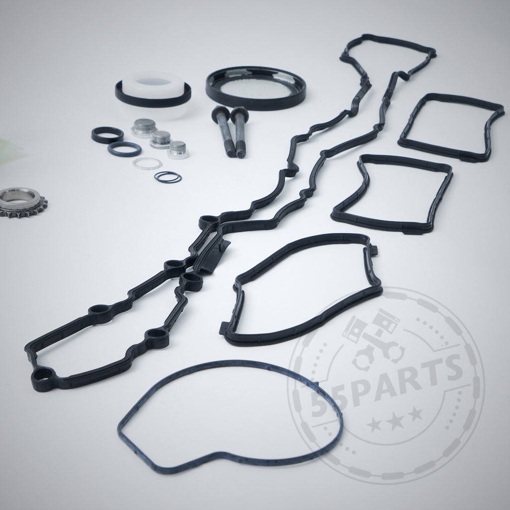 55Parts Exclusive Einbauset für einteiligen Crank Hub Fix/Kurbelwellensicherung passend für BMW M2 Competition, M3, M4 S55 sowie diverse schwarze Motordichtungen und Metallteile arrangiert auf weißem Grund mit verblasstem 55Parts Logo.