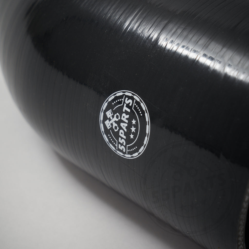 Nahaufnahme eines schwarz glänzenden 55Parts Silikon-Ansaugschlauchs für die BMW M40i(X) G-Serie (G20, G21, G22, G23, G26, G42 B58), mit weißem Logo und Sternen; inkl. Gutachten.