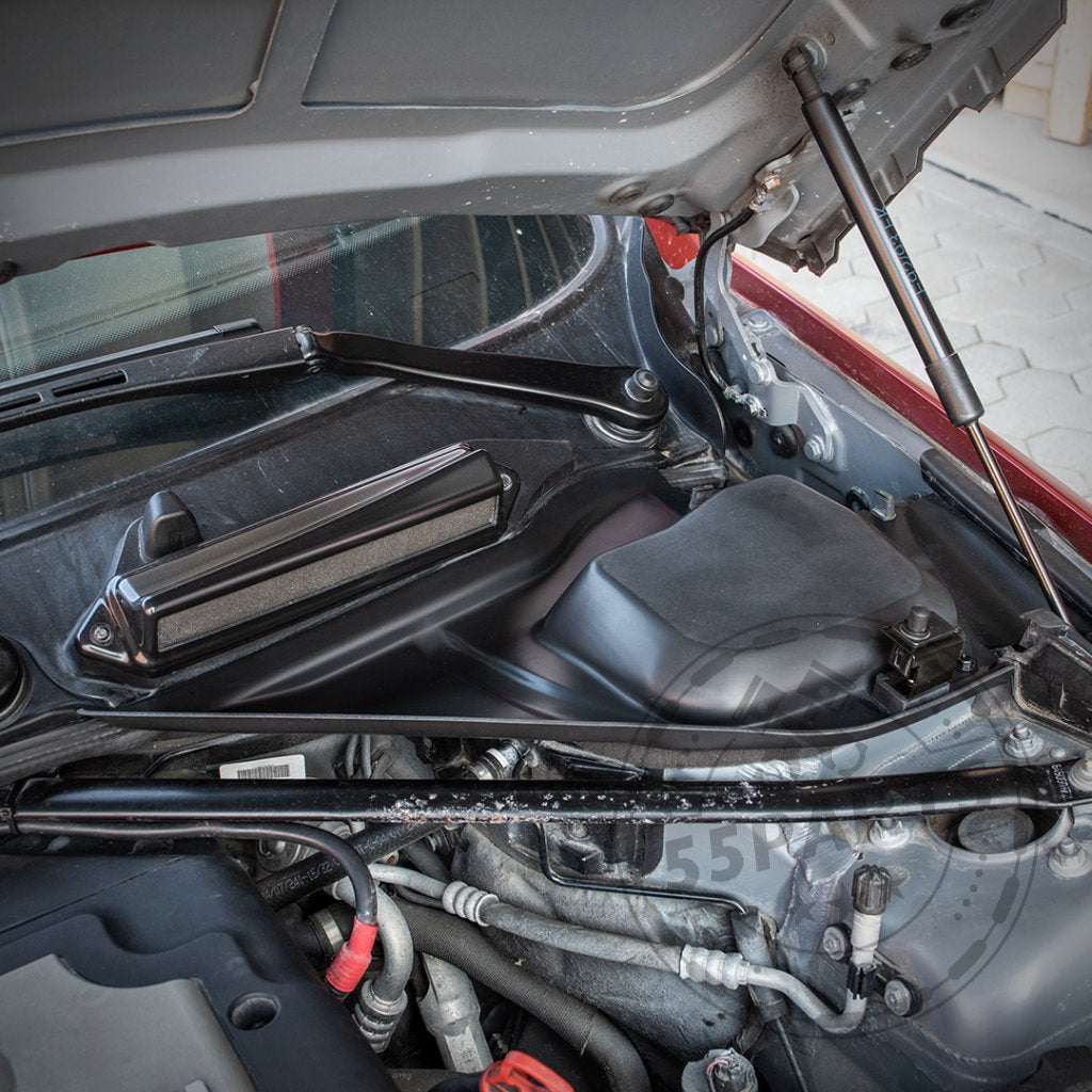 Nahaufnahme eines BMW-Motorraums mit dem Mikrofiltergehäuse-Unterteil von Bannik Engineering Exclusive, das für eine bessere Wärmeableitung entwickelt wurde und für die Modelle der 1er- und 3er-Reihe BMW E8x/E9x passt.