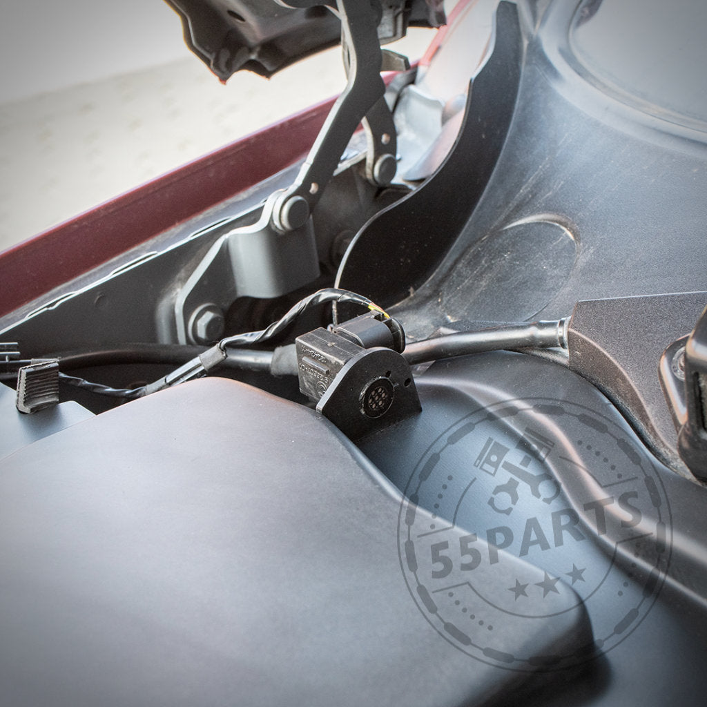 Nahaufnahme eines BMW-Motorraums mit Verkabelung, Anschlüssen und einem 55Parts-Wasserzeichen, mit dem Mikrofiltergehäuse-Unterteil von Bannik Engineering für verbesserte Wärmeableitung – passend für BMW E8x/E9x 1er und 3er.