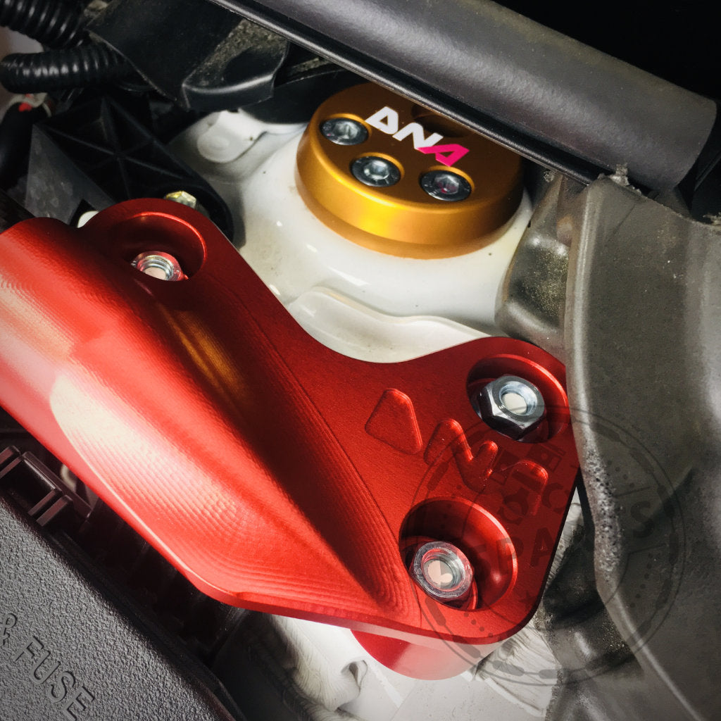 Werten Sie Ihren Toyota Yaris GR mit den verstellbaren Uniball Domlagern von DNA Racing auf – runde Halterungen in Gold und Schwarz mit roten Knöpfen, silbernen Schrauben und einem DNA Racing-Logo – ideal für Upgrades im Tuning-Shop.