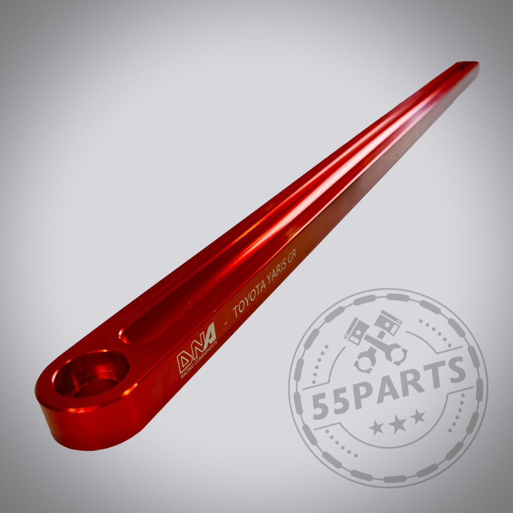 DNA Racing Versteifungsstrebe vorderer Achsträger vorne für Toyota Yaris GR, inkl. Bolzen und Unterlegscheiben, auf grauem Hintergrund präsentiert.