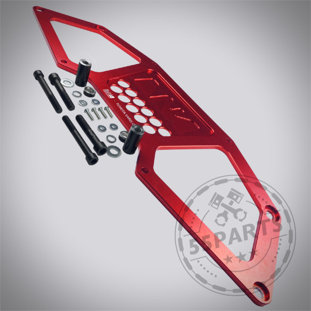 DNA Racing Versteifungsstrebe für den vorderen Achsträger hinten, passend für Toyota Yaris GR, auf hellem Hintergrund mit Montagematerial – ideal für Yaris GR Fans und Tuning Shop Upgrades.