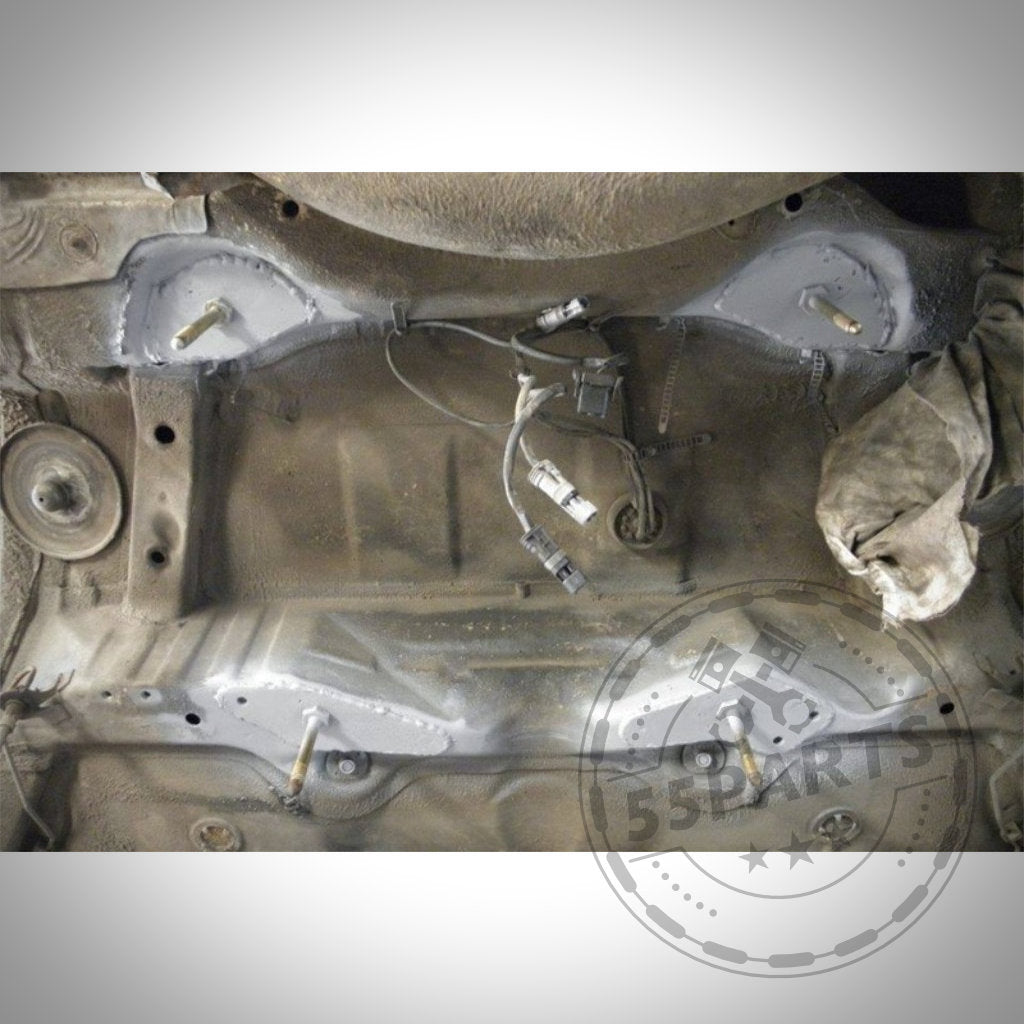 Der Unterboden zeigt geschweißte und grundierte Rahmenträger, freiliegende Kabel, Anschlüsse und Verstärkungsbleche Hinterachse passend für BMW 3er E36, sichtbar in der Nähe der Hinterachse.