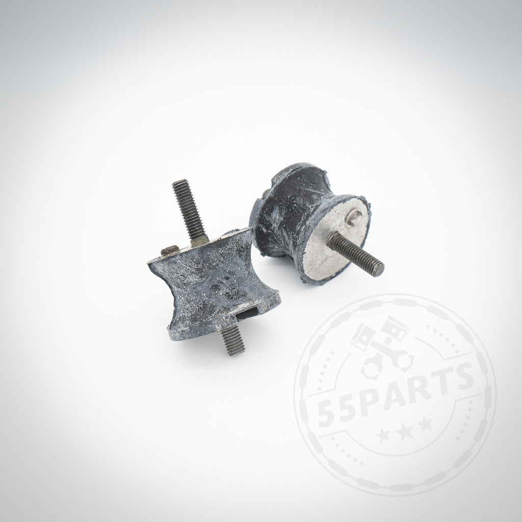 Auf weißem Untergrund sind zwei schwarze zylindrische 55Parts E46 M3 (Upgrade) Getriebelager, passend für BMW 135i, 1er M Coupé, 335i N54/N55 E-/F-Serie, mit Metallbolzen abgebildet – perfekt für präzises Schalten.