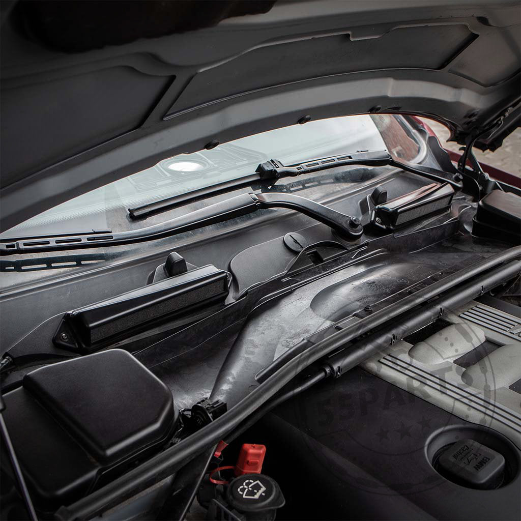 Geöffnete Motorhaube, sichtbar sind der N54/55-Motor und das Bannik Engineering Mikrofilter Delete Gehäuse, entwickelt für die BMW E8x/E9x 1er- und 3er-Reihe, eingebaut in der Nähe der Brandschutzwand und der Scheibenwischer.
